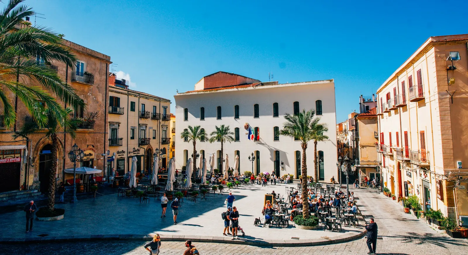 A sunny piazza with café tables in Italy