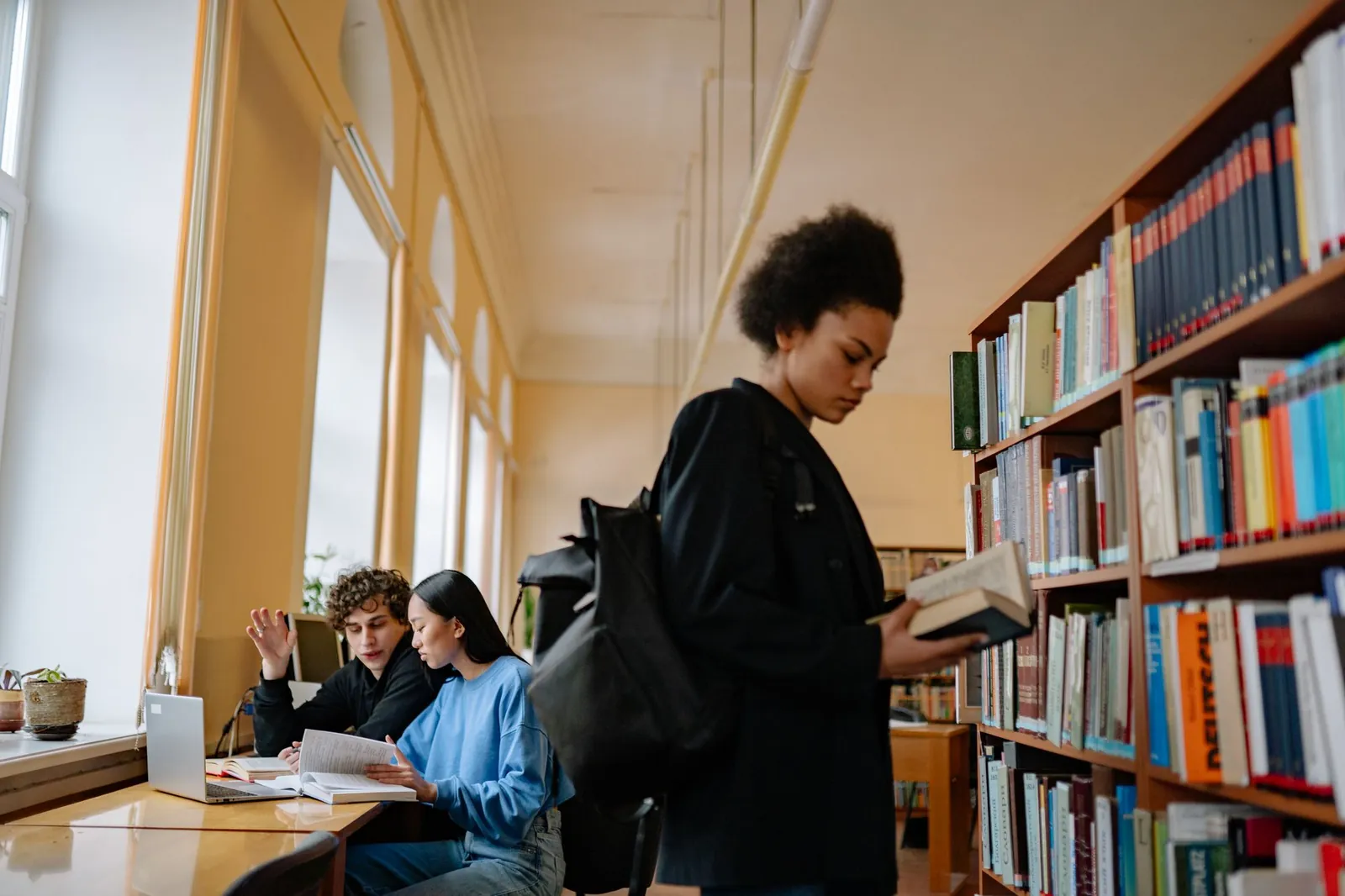 Teenagers studying among the shelves of a school library